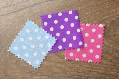 Photo of Samples of different fabrics on wooden table, flat lay