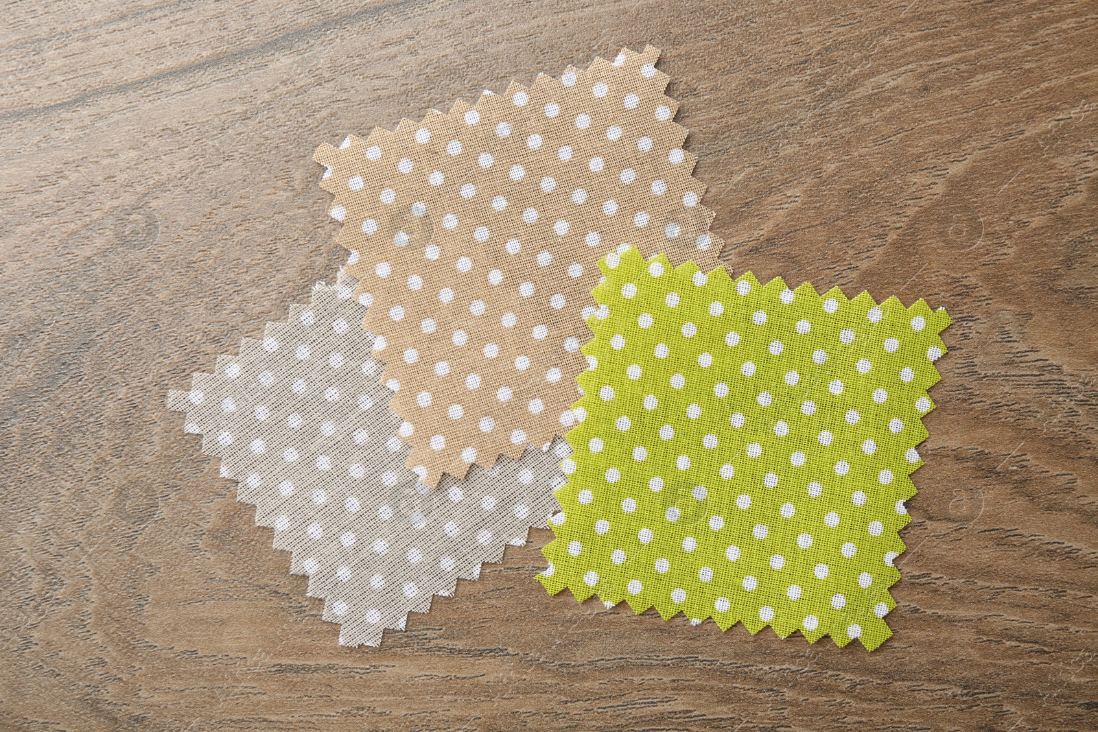 Samples of different fabrics on wooden table, flat lay Photo of Samples of different fabrics on wooden table, flat lay
