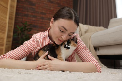 Photo of Woman with her cute calico kitten on floor at home