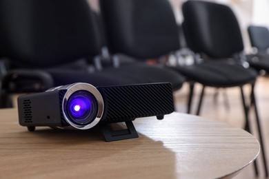 Photo of Modern video projector on table in conference room