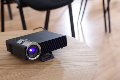 Photo of Modern video projector on table in conference room