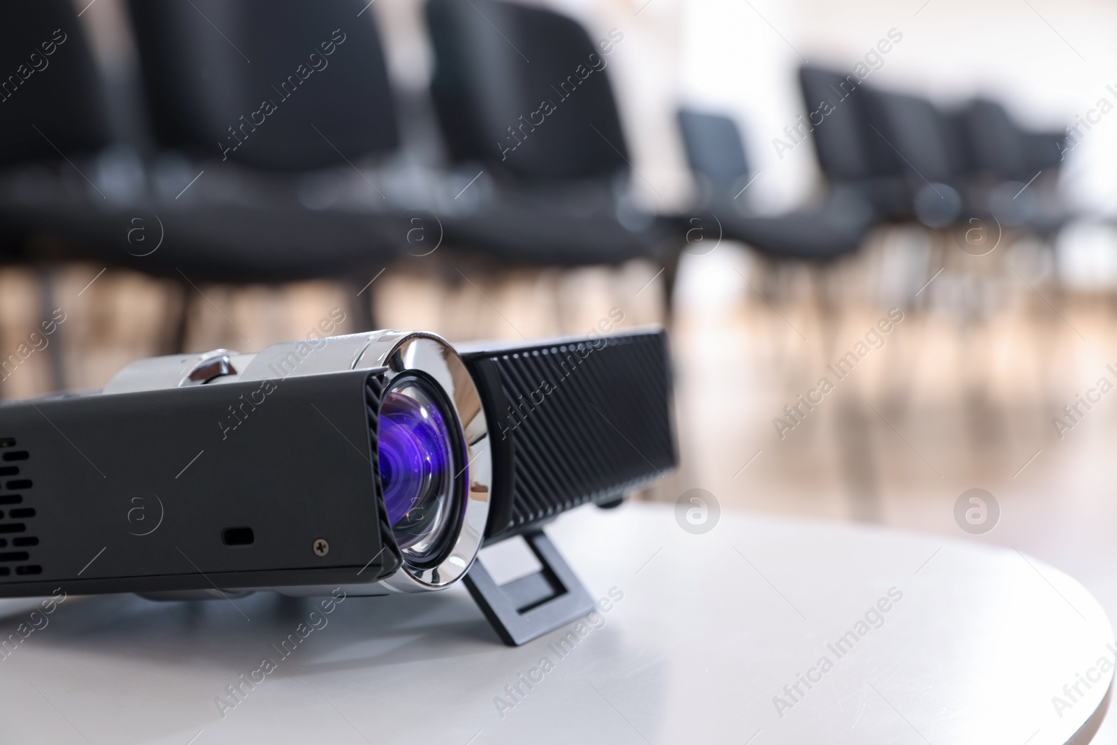 Modern video projector on table in conference room Photo of Modern video projector on table in conference room