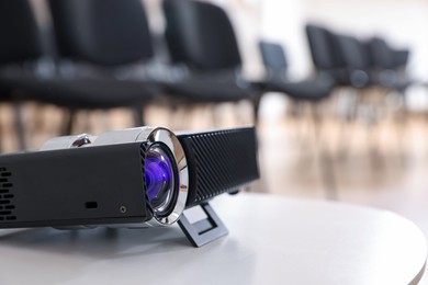 Photo of Modern video projector on table in conference room