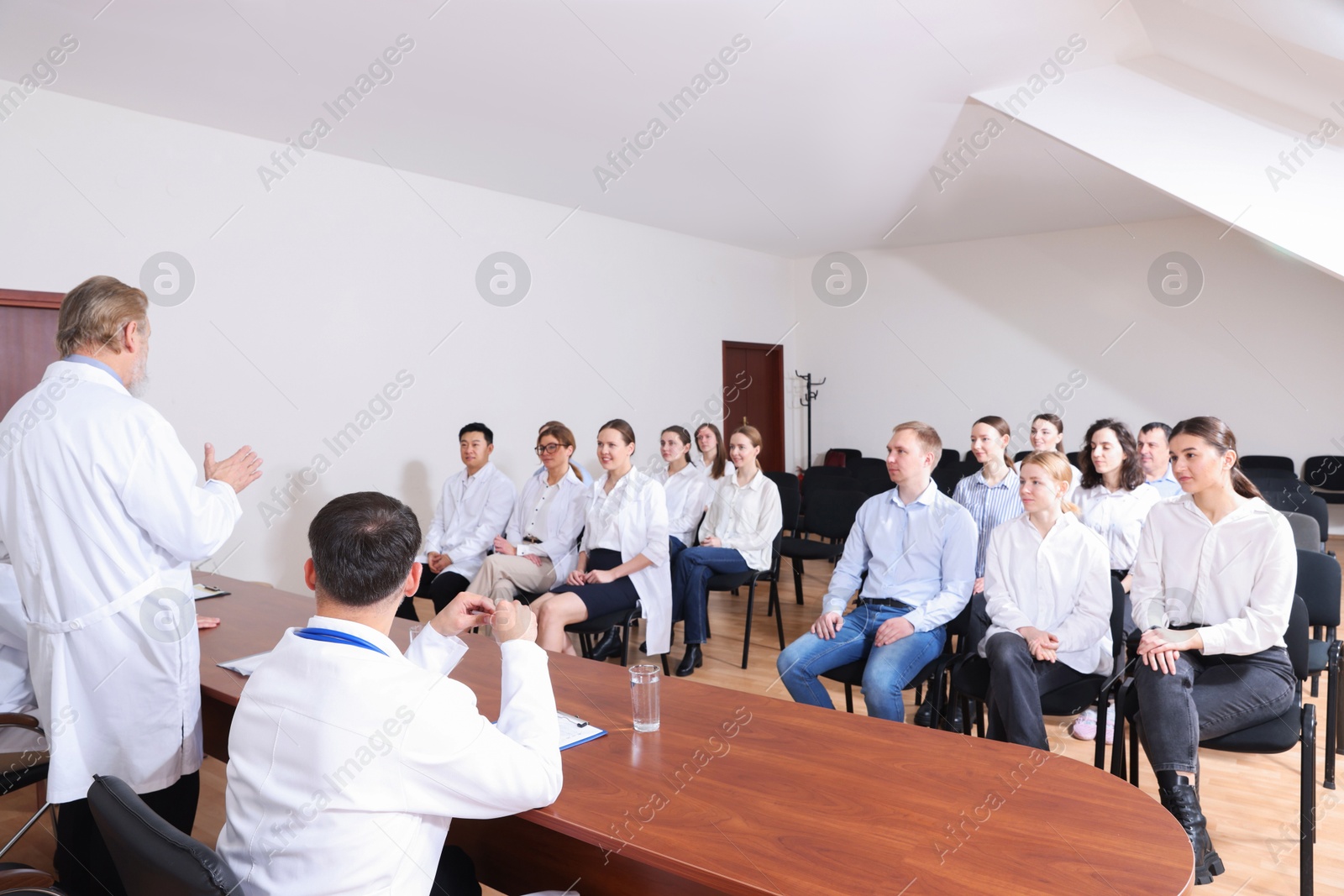 Doctors giving lecture to audience on medical conference in meeting room Photo of Doctors giving lecture to audience on medical conference in meeting room