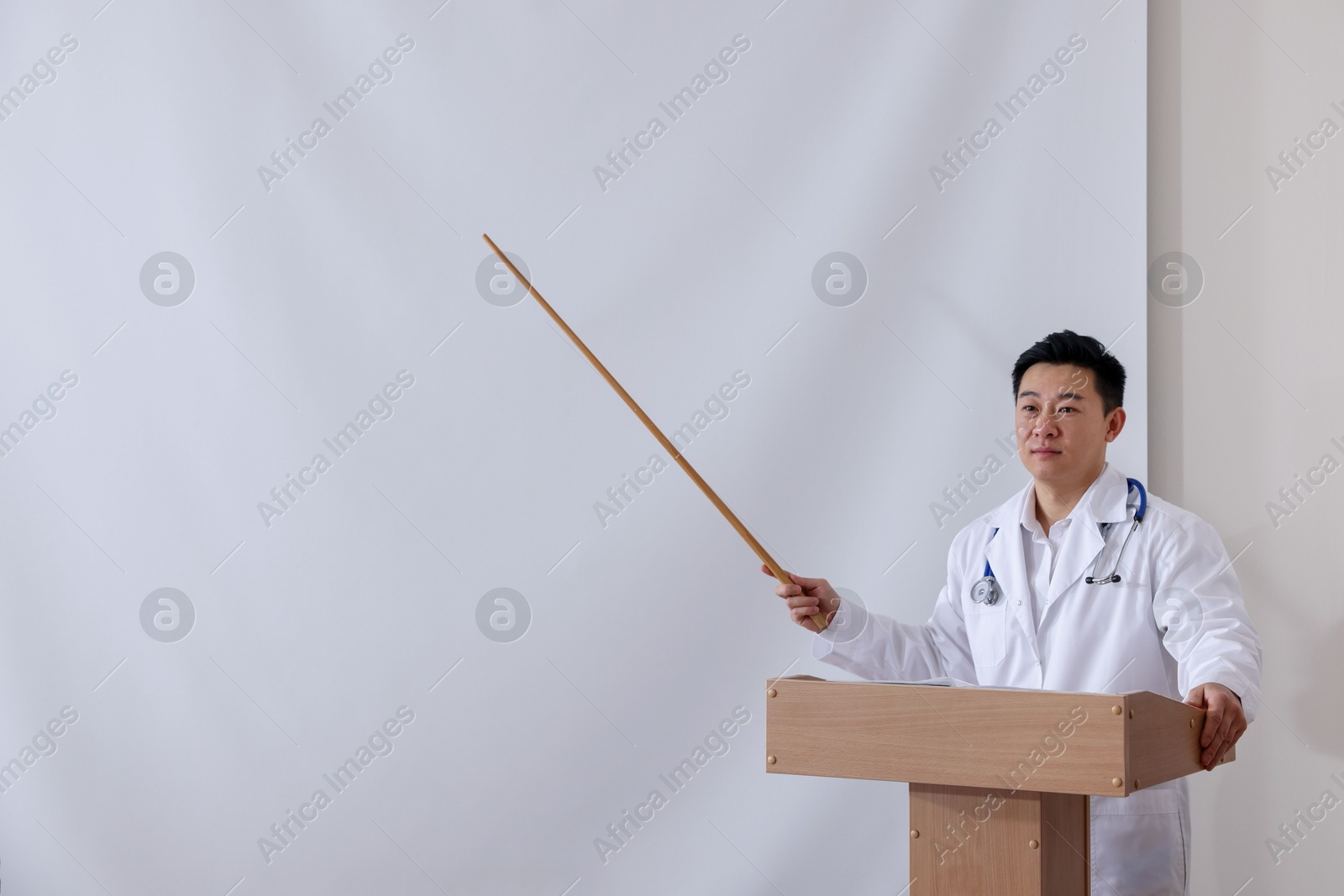 Doctor giving lecture in conference room with projection screen Photo of Doctor giving lecture in conference room with projection screen
