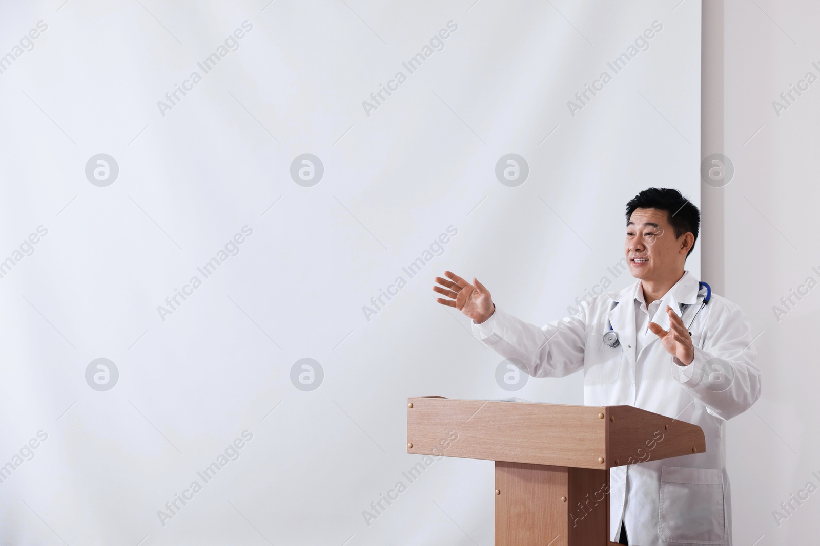 Doctor giving lecture in conference room with projection screen Photo of Doctor giving lecture in conference room with projection screen