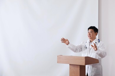 Photo of Doctor giving lecture in conference room with projection screen