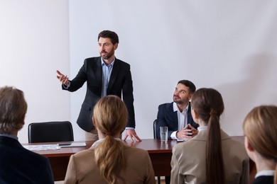 Photo of Business conference. People in meeting room listening to speaker report