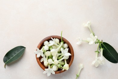 Photo of Bowl with jasmine flowers on beige table, flat lay. Space for text
