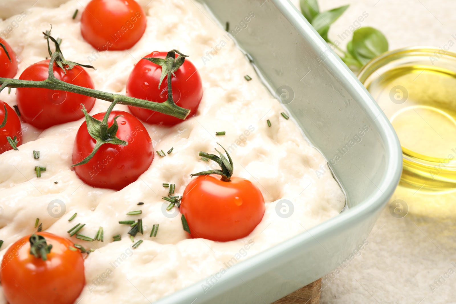 Raw focaccia with tomatoes and spices on light table, closeup Photo of Raw focaccia with tomatoes and spices on light table, closeup