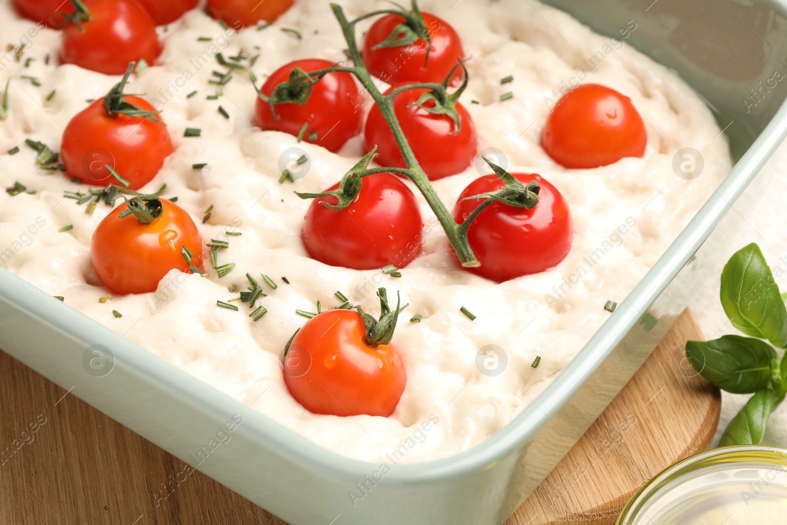 Raw focaccia with tomatoes and spices on table, closeup Photo of Raw focaccia with tomatoes and spices on table, closeup