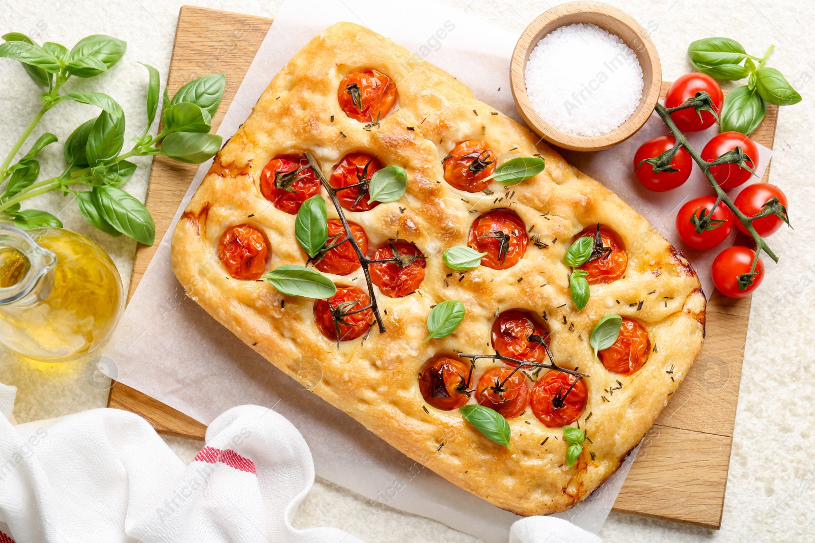 Delicious focaccia with tomatoes, spices and oil on beige table, flat lay Photo of Delicious focaccia with tomatoes, spices and oil on beige table, flat lay