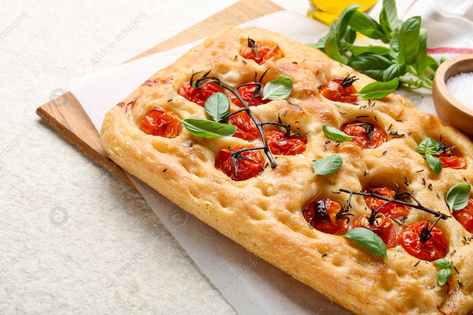 Delicious focaccia with tomatoes and spices on beige textured table, closeup Photo of Delicious focaccia with tomatoes and spices on beige textured table, closeup