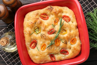 Photo of Delicious focaccia with tomatoes, spices and oil on table, flat lay
