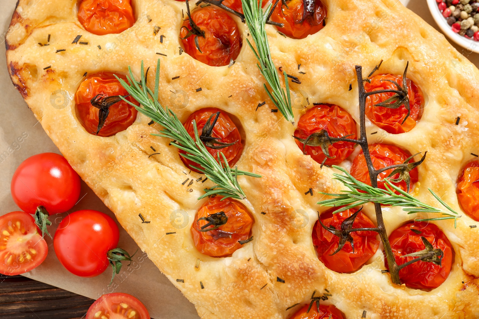 Delicious focaccia with tomatoes and spices on table, flat lay Photo of Delicious focaccia with tomatoes and spices on table, flat lay