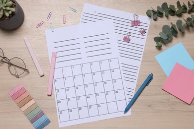 Photo of Planner and stationery on wooden table, flat lay