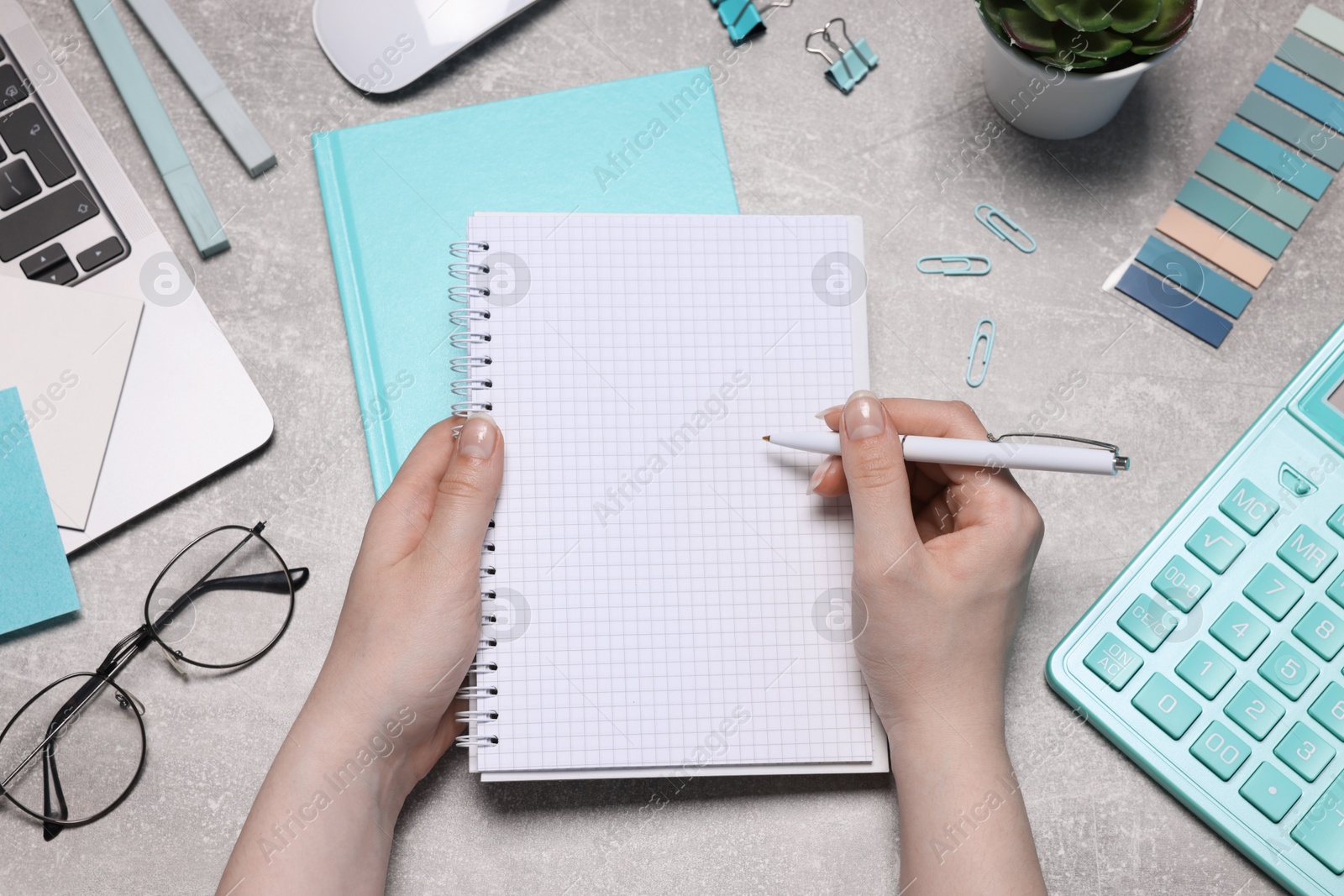 Woman with planner and stationery at grey textured table, top view Photo of Woman with planner and stationery at grey textured table, top view