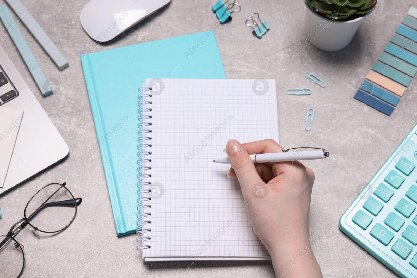 Woman with planner and stationery at grey textured table, top view Photo of Woman with planner and stationery at grey textured table, top view