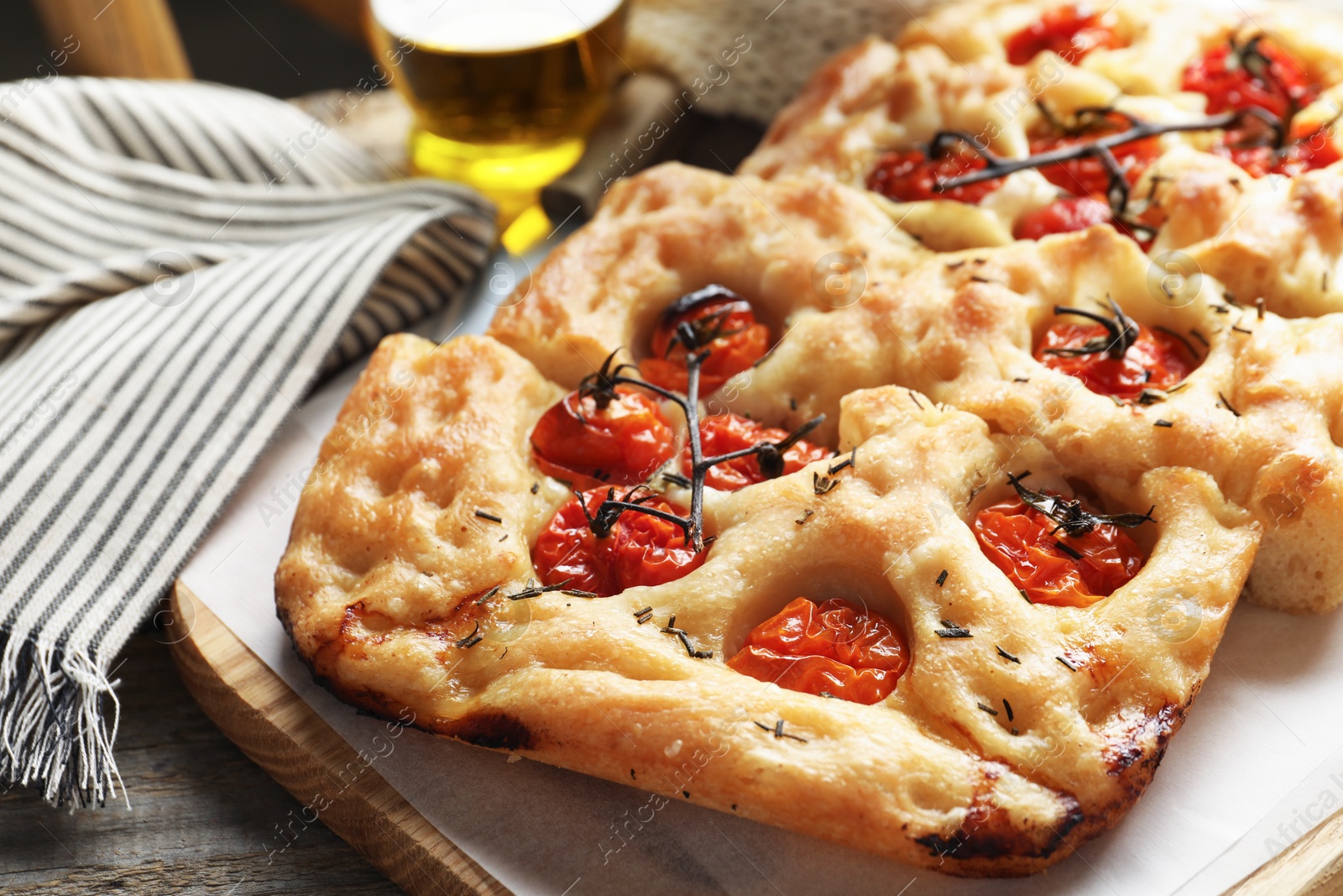 Cut delicious focaccia with tomatoes and spices on table, closeup Photo of Cut delicious focaccia with tomatoes and spices on table, closeup