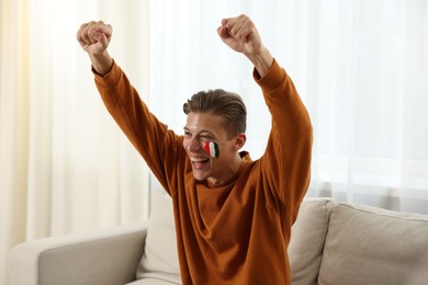 Photo of Emotional sports fan watching game at home