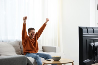 Photo of Emotional sports fan watching game at home
