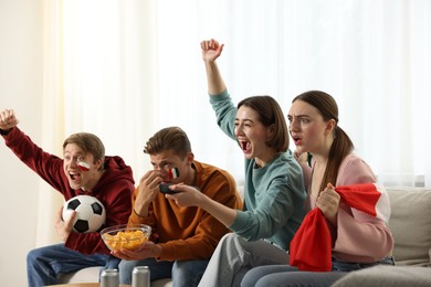 Photo of Emotional football fans watching game together indoors