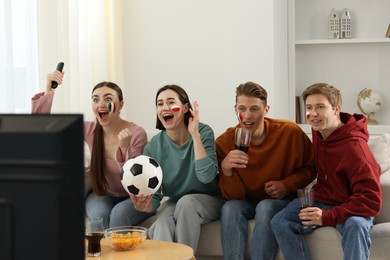 Photo of Emotional football fans watching game together indoors