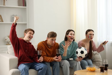 Photo of Emotional football fans watching game together indoors