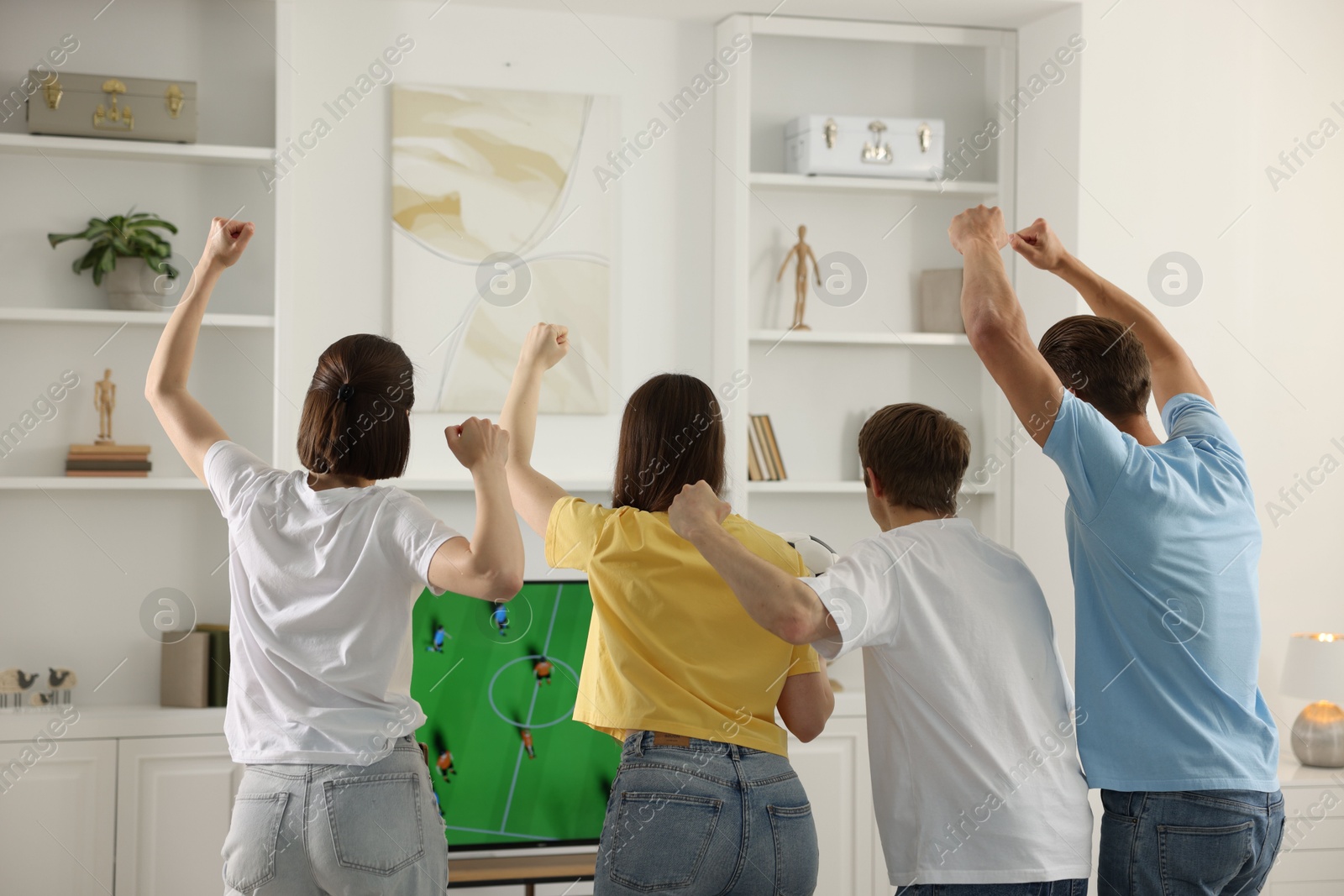 Group of football fans watching game together indoors, back view Photo of Group of football fans watching game together indoors, back view