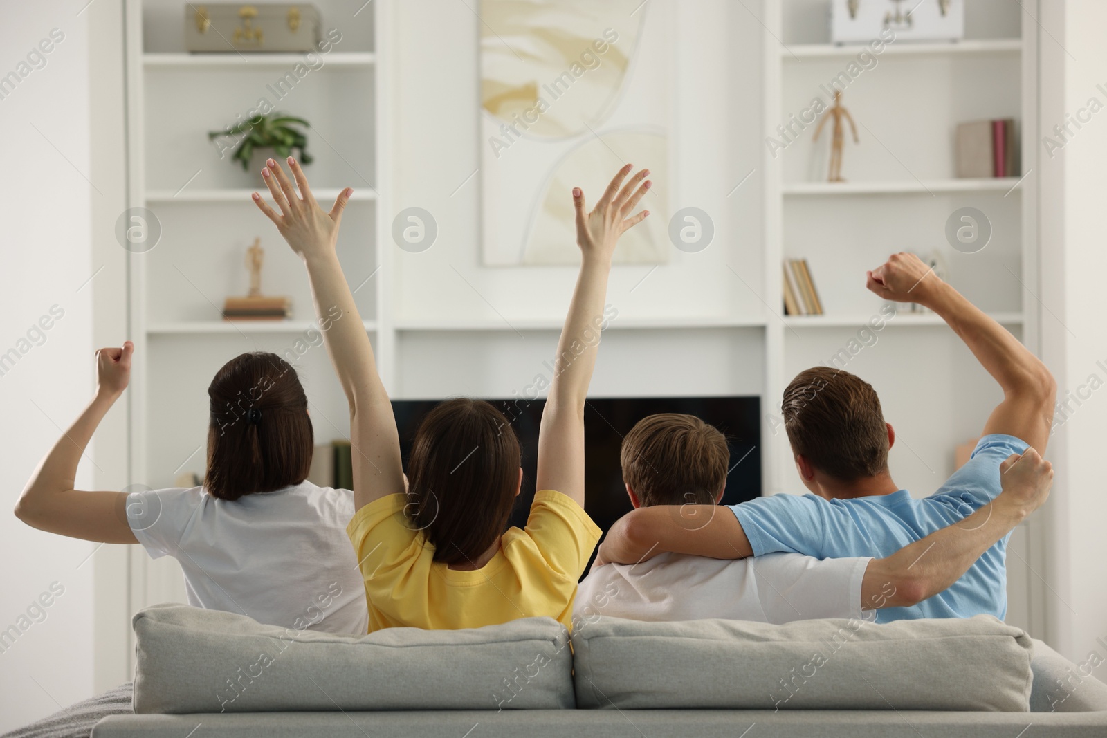 Group of football fans watching game together indoors, back view Photo of Group of football fans watching game together indoors, back view