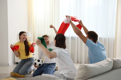Photo of Emotional football fans watching game together indoors