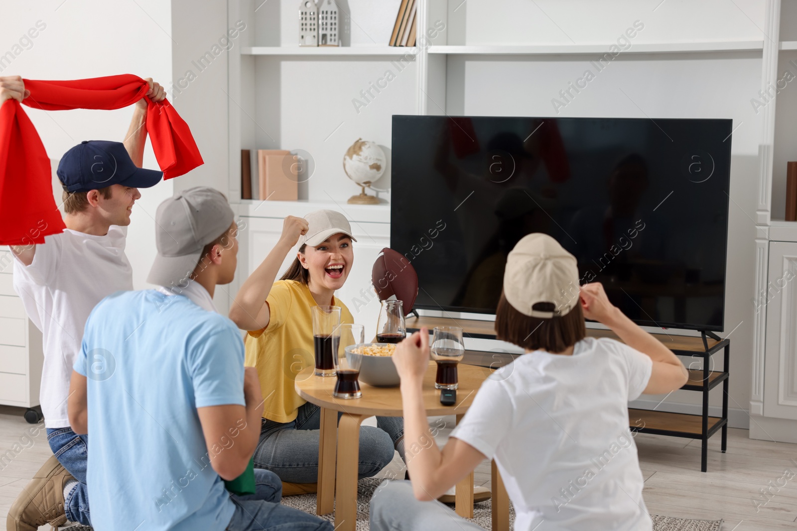 Emotional sports fans watching game together indoors Photo of Emotional sports fans watching game together indoors