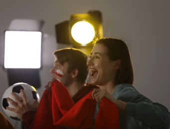 Photo of Emotional sports fans watching game together indoors