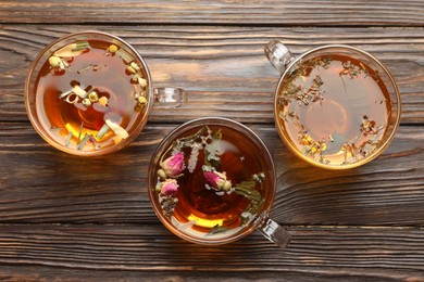 Photo of Aromatic herbal tea in glass cups on wooden table, flat lay