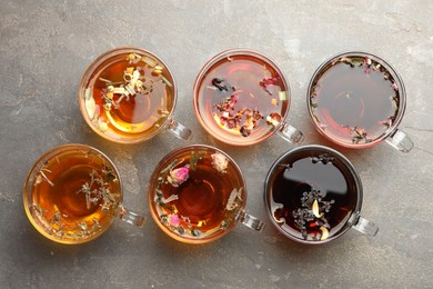 Photo of Aromatic herbal tea in glass cups on grey table, flat lay