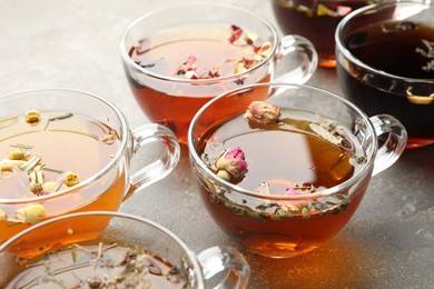 Photo of Aromatic herbal tea in glass cups on grey table, closeup