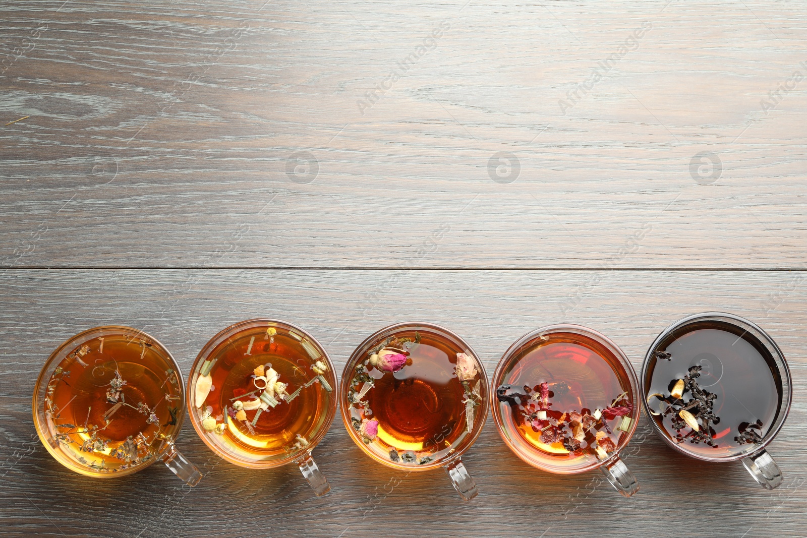 Aromatic herbal tea in glass cups on wooden table, flat lay. Space for text Photo of Aromatic herbal tea in glass cups on wooden table, flat lay. Space for text