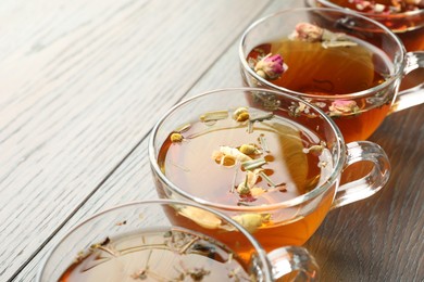 Photo of Aromatic herbal tea in glass cups on wooden table, closeup