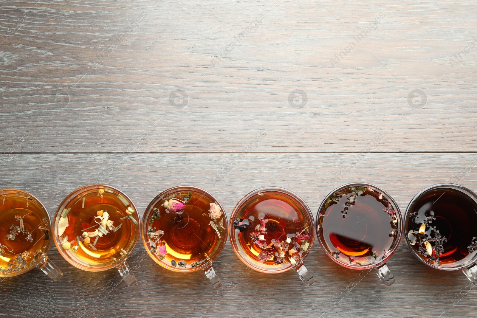 Aromatic herbal tea in glass cups on wooden table, flat lay. Space for text Photo of Aromatic herbal tea in glass cups on wooden table, flat lay. Space for text
