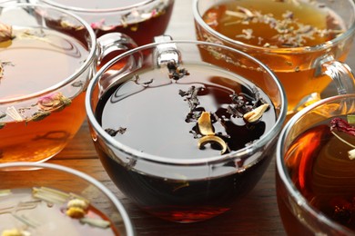Photo of Aromatic herbal tea in glass cups on wooden table, closeup