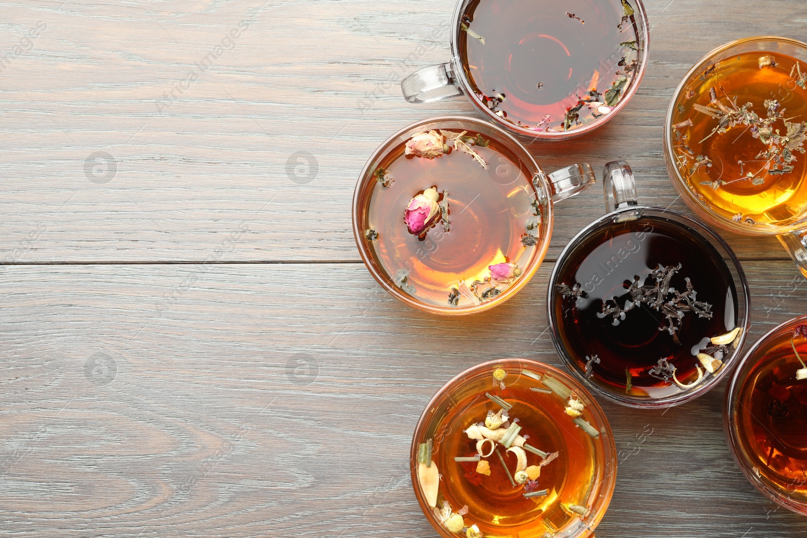 Aromatic herbal tea in glass cups on wooden table, flat lay. Space for text Photo of Aromatic herbal tea in glass cups on wooden table, flat lay. Space for text