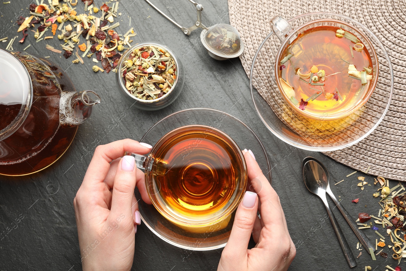Woman with aromatic herbal tea at black table, top view Photo of Woman with aromatic herbal tea at black table, top view