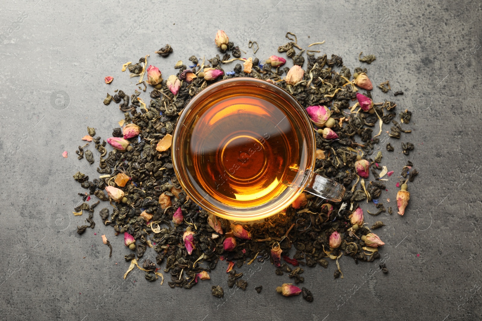 Aromatic herbal tea, dry leaves and flowers on grey table, flat lay Photo of Aromatic herbal tea, dry leaves and flowers on grey table, flat lay