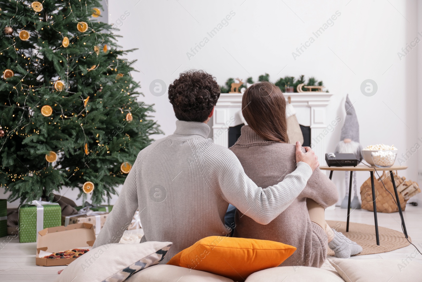 Couple watching movie via video projector at home, back view Photo of Couple watching movie via video projector at home, back view