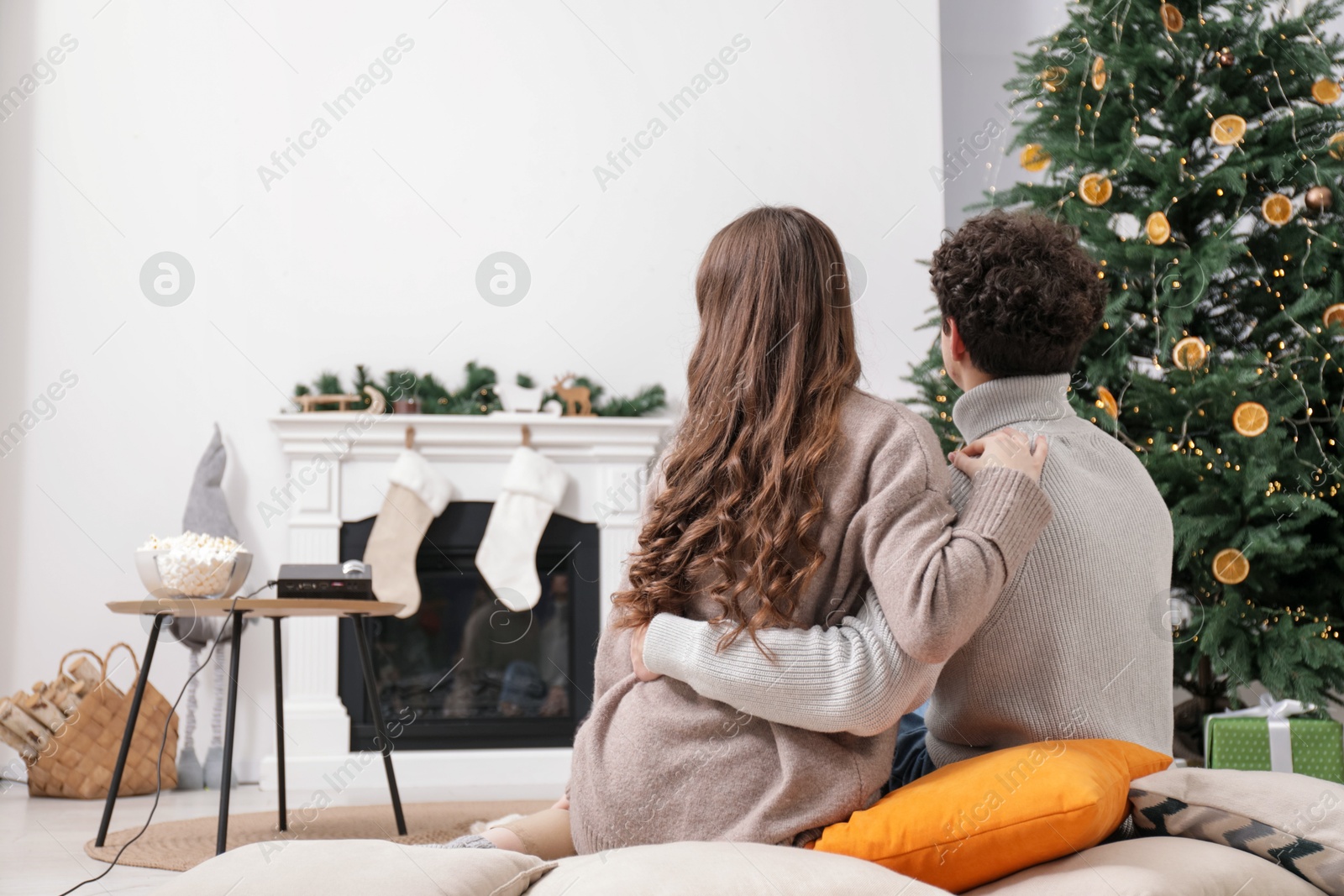 Couple watching movie via video projector at home, back view Photo of Couple watching movie via video projector at home, back view