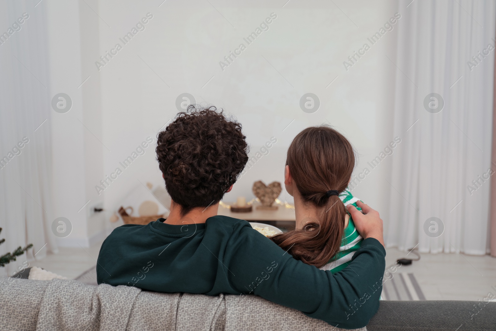 Couple watching movie via video projector at home Photo of Couple watching movie via video projector at home