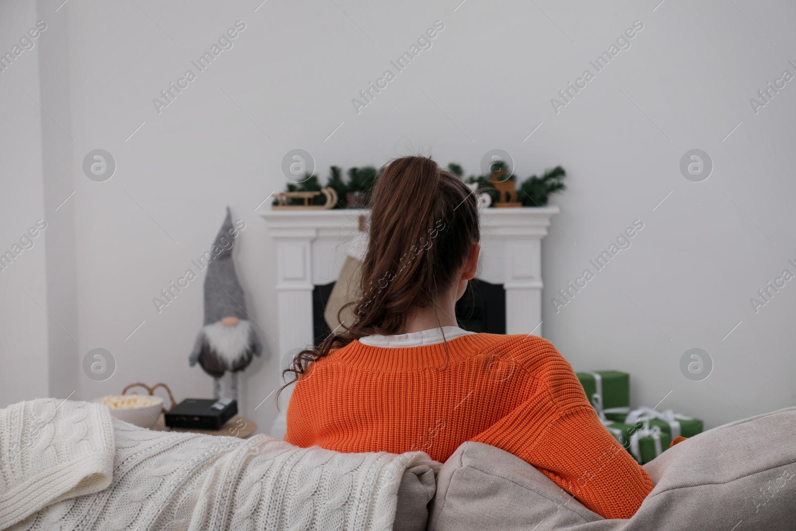Woman watching movie via video projector at home, back view Photo of Woman watching movie via video projector at home, back view