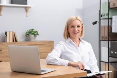 Photo of Professional psychologist with notebook at table in office