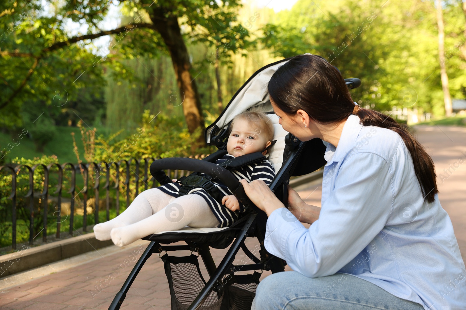 Mother with her cute baby in stroller at park Photo of Mother with her cute baby in stroller at park