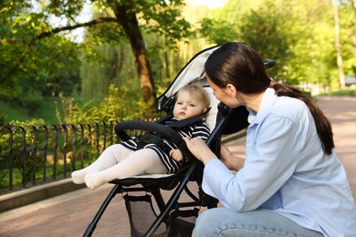 Photo of Mother with her cute baby in stroller at park